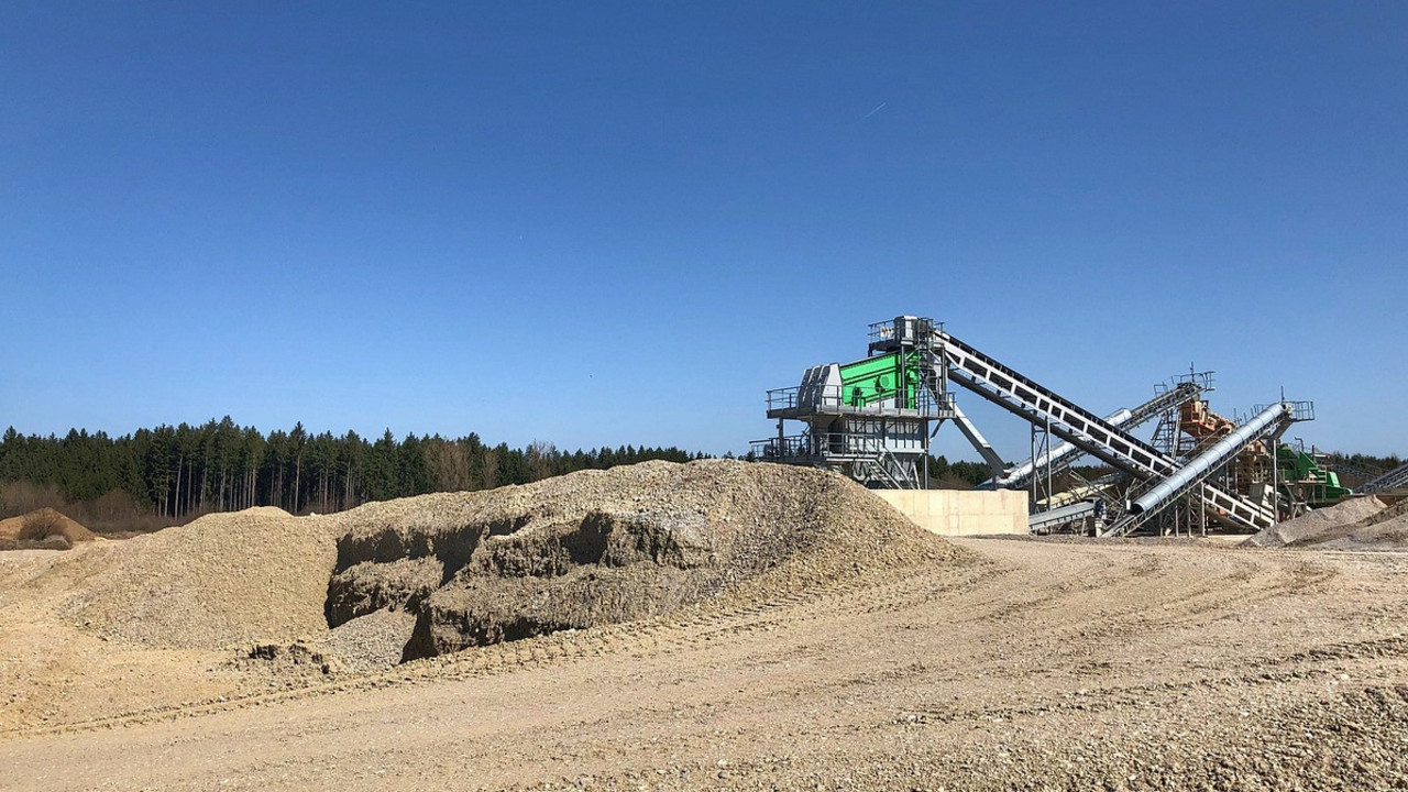 Bagger auf einem Kiesberg