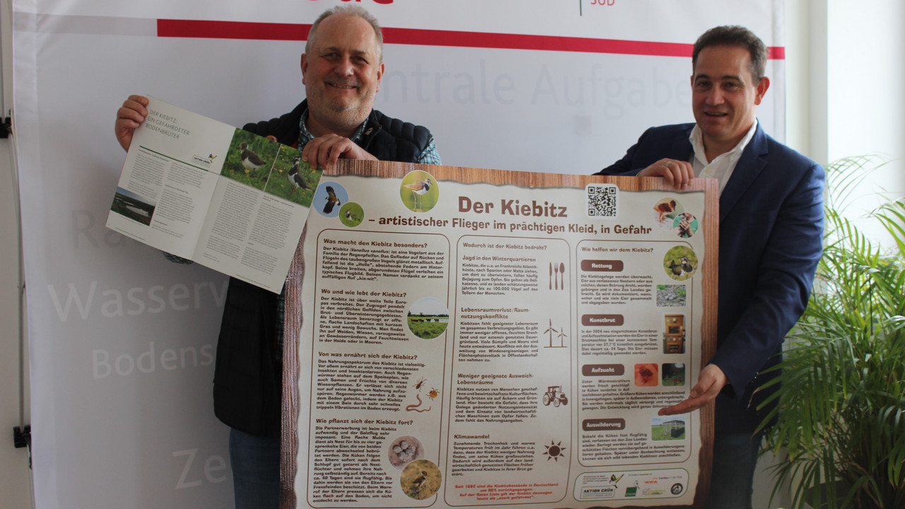 Landaus Zoodirektor Heckel übergibt ein Informationsposter zum Kiebitzschutz an SGD Süd-Präsidenten Kopf 